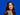 Bild zeigt Anna Lerchen vor blauem Hintergrund, lächelnd in die Kamera