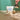 Produktaufnahme der Barista Oat Base von Blue Farm mit Löffel im Vordergrund. Der Drink wird aus einer kleinen Milchkanne in ein Glas geschüttet