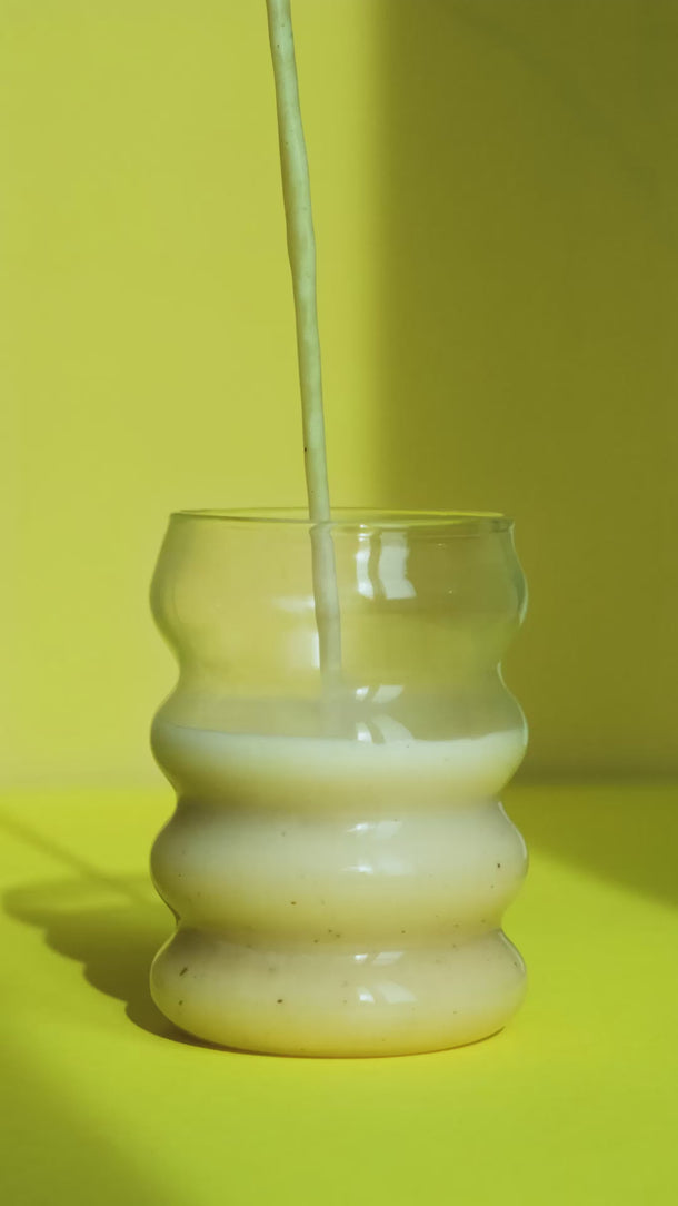 Vanille Oat Base wird in ein Glas gegossen – das Glas füllt sich langsam.