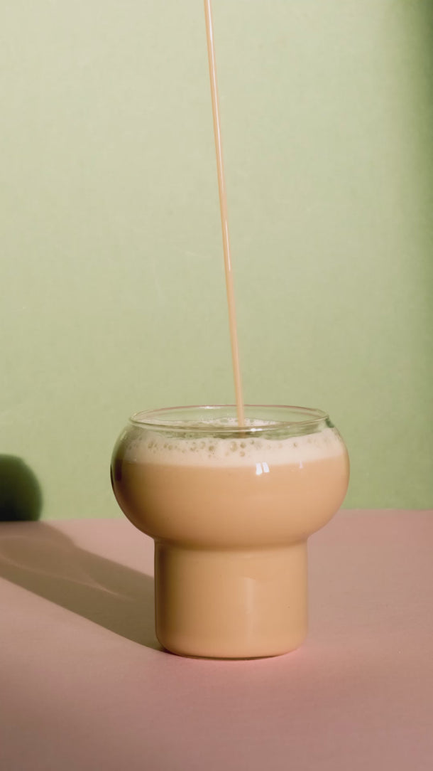 Video des Hazelnut Oat Latte, der in ein Glas eingeschenkt wird bis es übergeht.