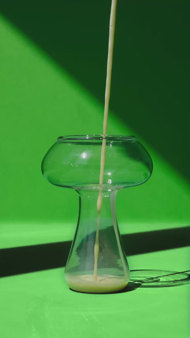 Ein Glas, das sich nacheinander mit Zutaten füllt und in einen fertigen Drink verwandelt.